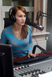 Portrait of female dj working in front of a microphone