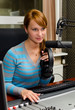 Female dj working in front of a microphone on the radio