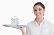 Foto: Waitress holding alarm clock on a tray Waitress holding alarm clock on a tray