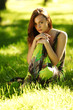 brunette sitting on green grass