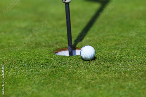 Photo: golf ball on lip of cup golf ball on lip of cup