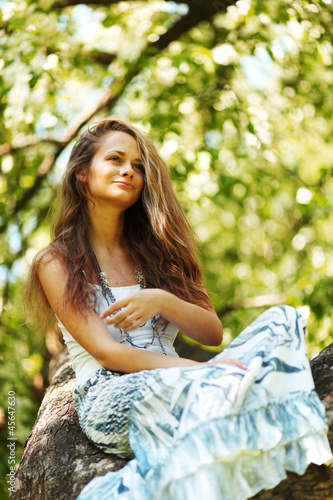 Photo: woman sitting on tree woman sitting on tree