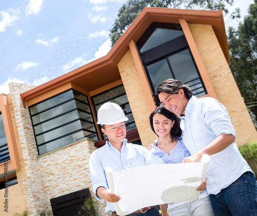 Photo: Couple talking to architect about a house Couple talking to architect about a house