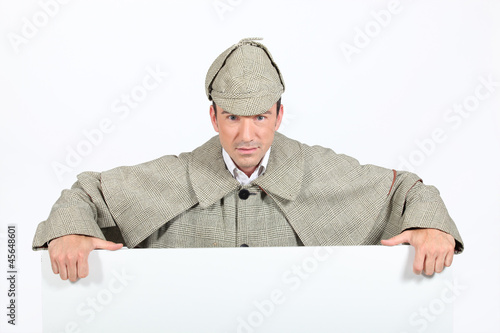 Photo: Man in deerstalker and cape leaning on a board Man in deerstalker and cape leaning on a board