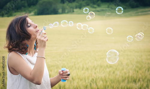 Photo: Romantic portrait of young woman with soap balloons. Romantic portrait of young woman with soap balloons.