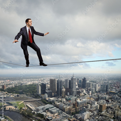 Photo: Balancing businessman and cityscape Balancing businessman and cityscape