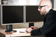 Mann im Büro vor PC Bildschirmen