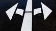 zwei weiße pfeile und schwarzer asphalt auf der straße
