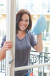 Photo: Young woman cleaning windowpane Young woman cleaning windowpane