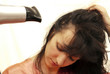 The woman dries hair the hair dryer