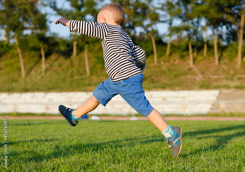 Photo: Little boy midair kicking a ball Little boy midair kicking a ball