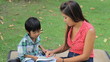 Asian Mother Teaches Son To Read At The Park
