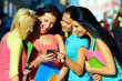 group of female students chatting in social network on phone