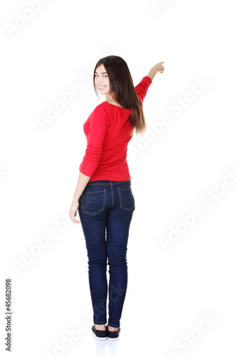 Photo: Happy , excited young woman pointing on copy space Happy , excited young woman pointing on copy space