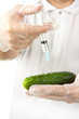 Hands making injection to cucumber