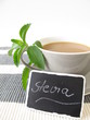 Milchkaffee mit Stevia und beschrifteter Tafel