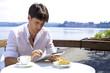 Serious man working with tablet in front of lake