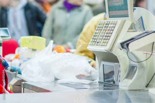 Photo: Cash-desk with cashier and terminal in supermarket. Serve custom Cash-desk with cashier and terminal in supermarket. Serve custom