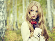 Fashion portrait of a beautiful young woman in autumn forest