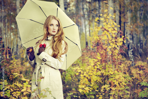 Photo: Fashion portrait of a beautiful young woman in autumn forest Fashion portrait of a beautiful young woman in autumn forest
