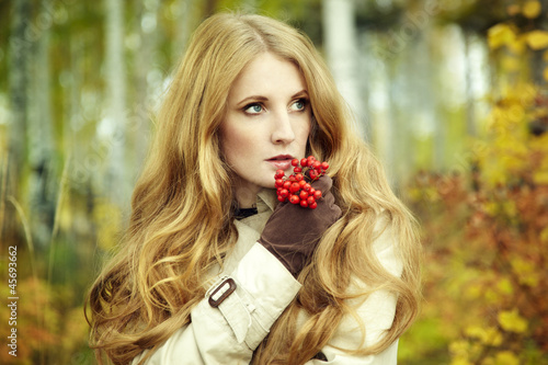 Photo: Fashion portrait of a beautiful young woman in autumn forest Fashion portrait of a beautiful young woman in autumn forest