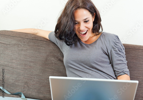 Photo: Cheerful woman in front of her laptop Cheerful woman in front of her laptop