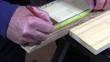 Man drilling a large hole in a piece of wood.