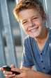 Close up portrait of boy with phone outdoors.