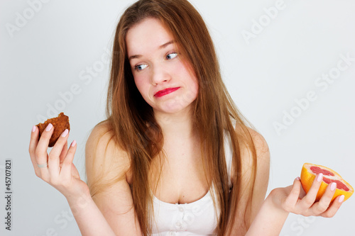 Photo: young beautiful girl with fruit and cake in her hands young beautiful girl with fruit and cake in her hands