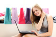 Woman with laptop on hands and shopping bags behind her