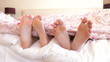 Close Up Of Couple's Feet In Bed