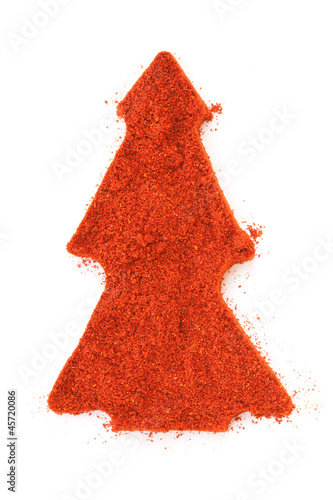 Photo: Pile of ground Paprika isolated in christmas tree shape on white Pile of ground Paprika isolated in christmas tree shape on white