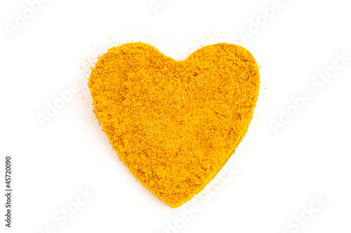 Photo: Heap ground Curry (Madras Curry) isolated in heart shape on whit Heap ground Curry (Madras Curry) isolated in heart shape on whit