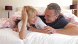 Senior Couple Chatting In Bed Together