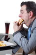 Businessman eating junk food while working