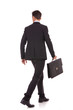 back view of a walking business man with briefcase