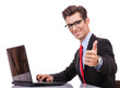 business man working at his laptop making ok sign