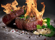 Grilled bbq steaks with fire flames