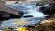 small cascade waterfall with reflecting fall foliage