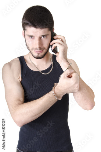 Photo: Young criminal listening on phone Young criminal listening on phone