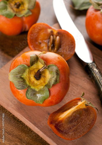 Photo: persimmon on a wooden table persimmon on a wooden table