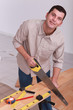 Man sawing wooden floorboards