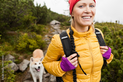 Photo: Happy woman hiking in mountains with akita dog, Poland Happy woman hiking in mountains with akita dog, Poland