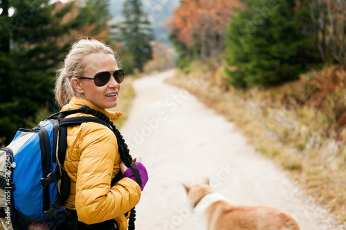 Photo: Woman hiking in mountains with akita dog Woman hiking in mountains with akita dog