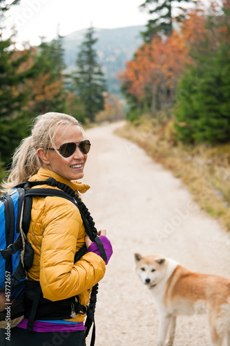 Photo: Woman hiking in mountains with akita dog Woman hiking in mountains with akita dog