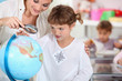 schoolmistress teaching geography with globe