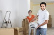 Couple carrying carpet into home