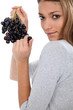 Photo: a young woman savouring sensually a grape a young woman savouring sensually a grape