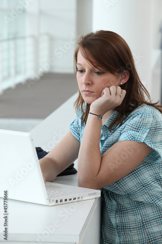 Photo: Brunette teenager concentrating on computer screen Brunette teenager concentrating on computer screen