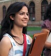 Young Indian / Asian college student holding a file folder.